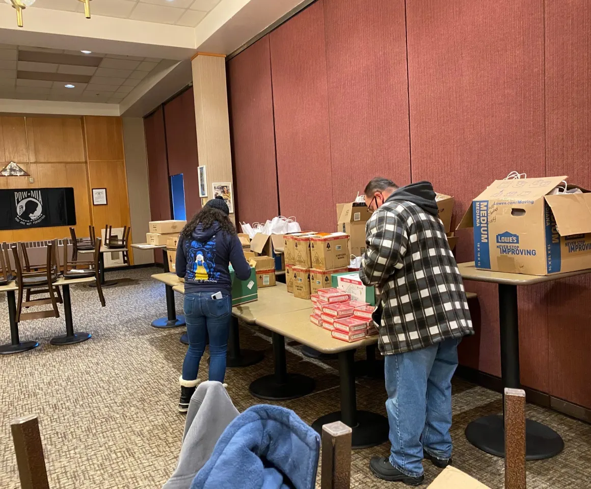 Two volunteers unpacking boxes at the Holiday Meals for Military event
